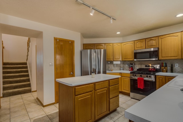 kitchen featuring light tile patterned floors, decorative backsplash, a center island, and appliances with stainless steel finishes