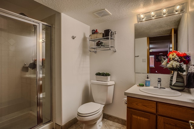 bathroom with a shower with door, vanity, a textured ceiling, tile patterned floors, and toilet