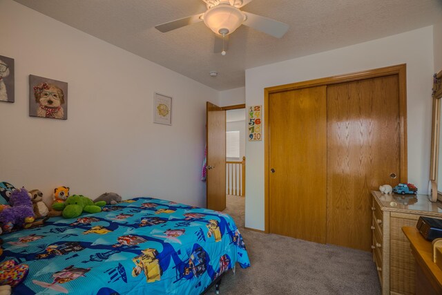 bedroom featuring ceiling fan, a closet, a textured ceiling, and carpet