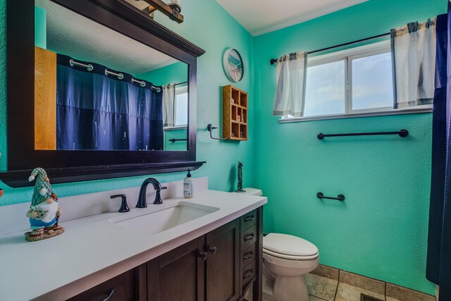 bathroom featuring tile patterned flooring, vanity, and toilet