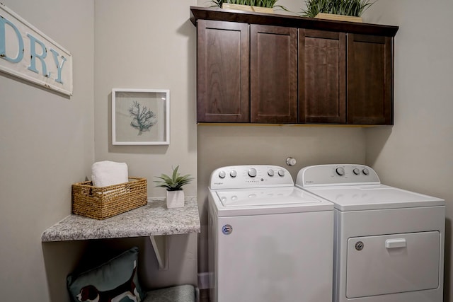 laundry area with washer and clothes dryer and cabinets