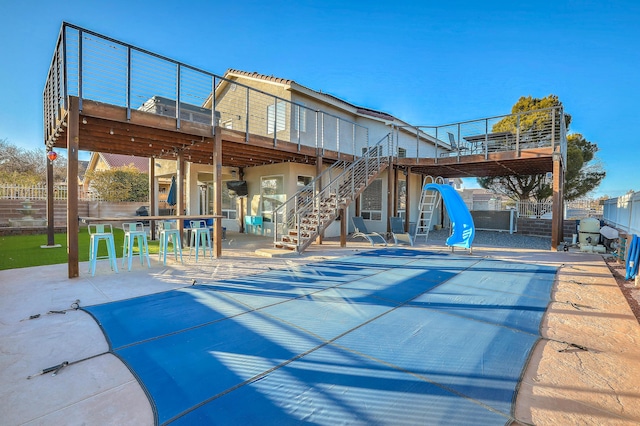 rear view of property with a wooden deck and a patio area