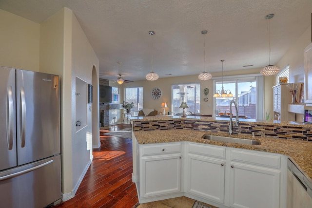 kitchen with white cabinetry, appliances with stainless steel finishes, sink, and stone counters