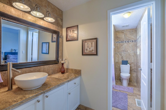 bathroom featuring vanity, tile walls, and toilet