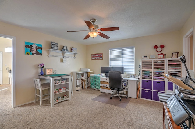 carpeted office space featuring ceiling fan and a textured ceiling