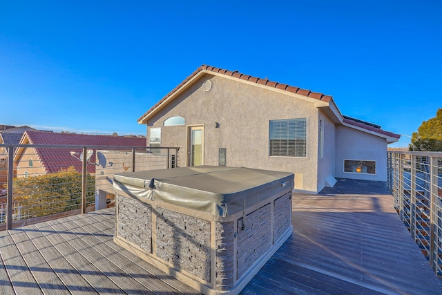 rear view of property featuring a fireplace and a hot tub