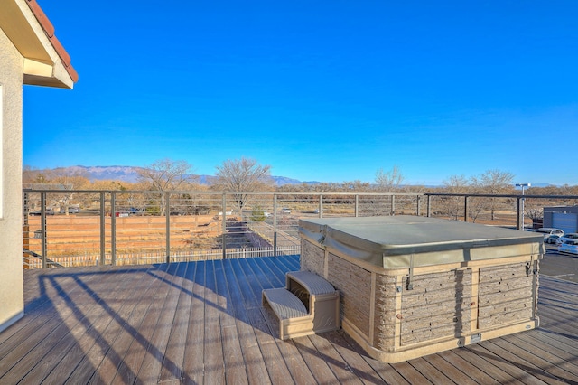 wooden deck with a mountain view and a hot tub