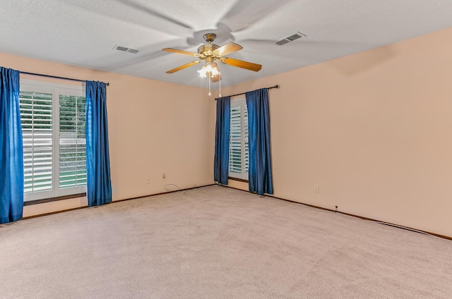 carpeted spare room with ceiling fan and a textured ceiling