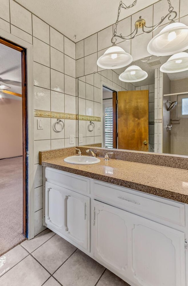 bathroom featuring vanity, tile patterned flooring, and tile walls