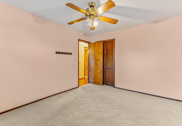 carpeted spare room with ceiling fan