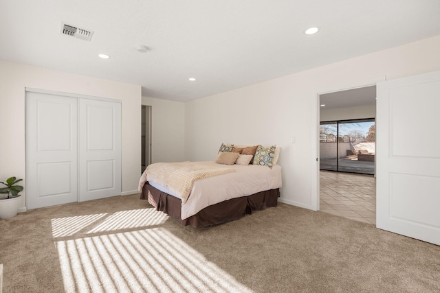 bedroom featuring light carpet and a closet