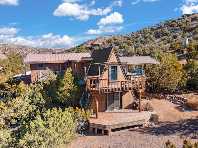 rear view of house with a deck with mountain view