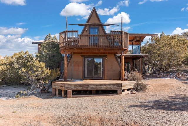 rear view of property featuring a wooden deck