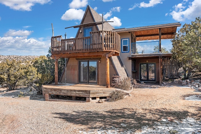 back of property featuring a balcony and a deck