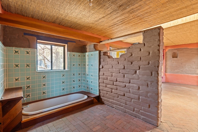 bathroom with wood ceiling and a bathing tub