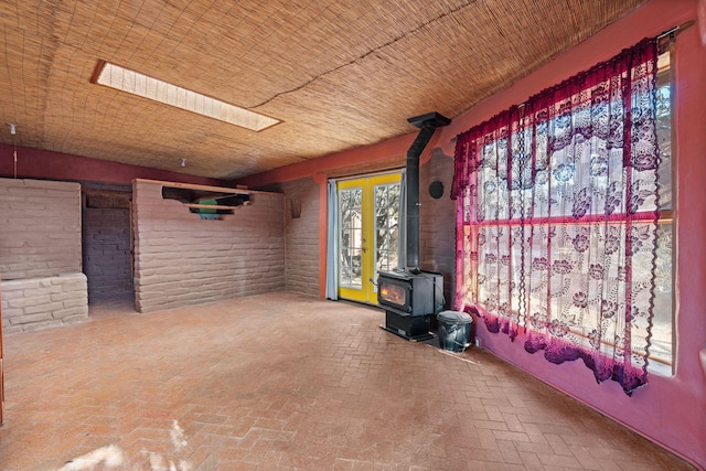 interior space with brick wall and a wood stove