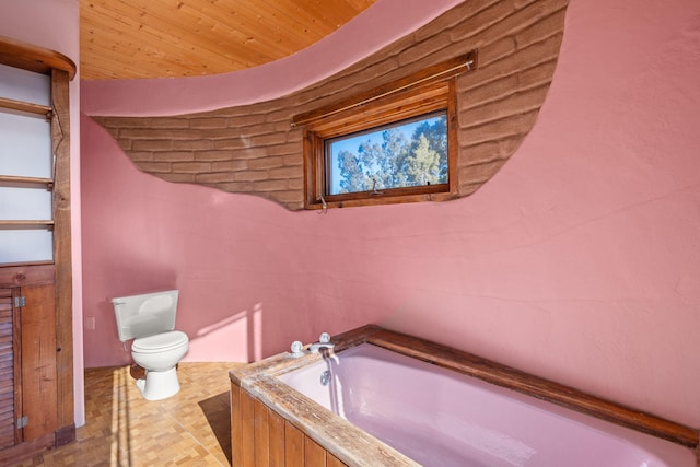 bathroom featuring a washtub and toilet