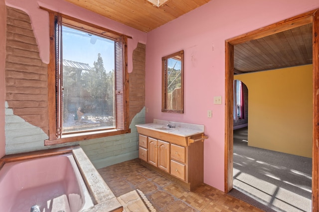 bathroom with vanity, a bath, parquet flooring, and wooden ceiling