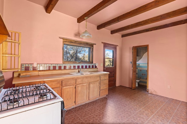 kitchen with sink, beam ceiling, and white gas range oven