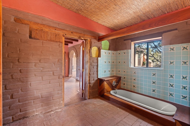 bathroom featuring a bathtub and brick ceiling