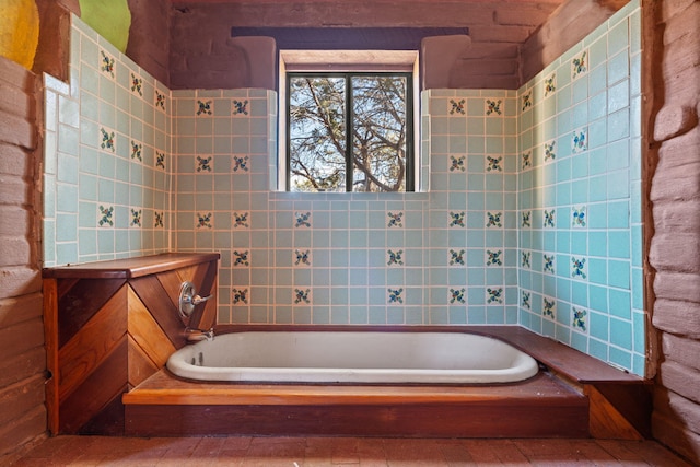 bathroom featuring tile walls and tiled tub