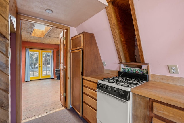 kitchen featuring french doors, a skylight, and gas range gas stove