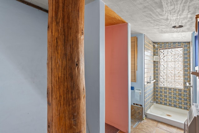 bathroom featuring tile patterned floors and a tile shower