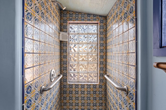 bathroom with lofted ceiling and tiled shower