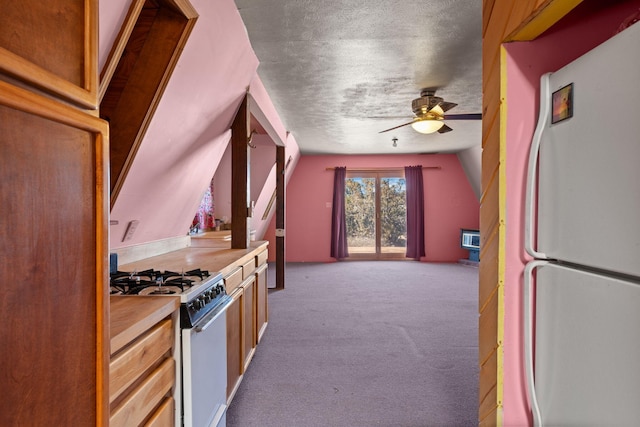 kitchen with lofted ceiling, light colored carpet, white appliances, ceiling fan, and a textured ceiling