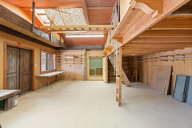 basement featuring wooden walls