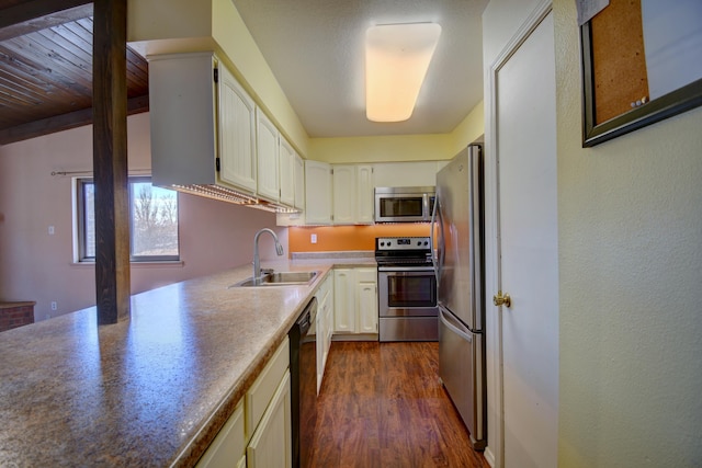 kitchen featuring white cabinetry, appliances with stainless steel finishes, dark wood-type flooring, and sink