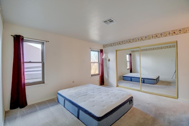 bedroom with light colored carpet and a closet