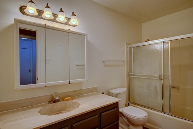 full bathroom featuring shower / bath combination with glass door, vanity, and toilet