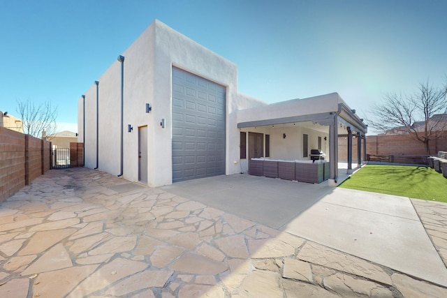 exterior space with a garage, an outdoor hangout area, and a patio area