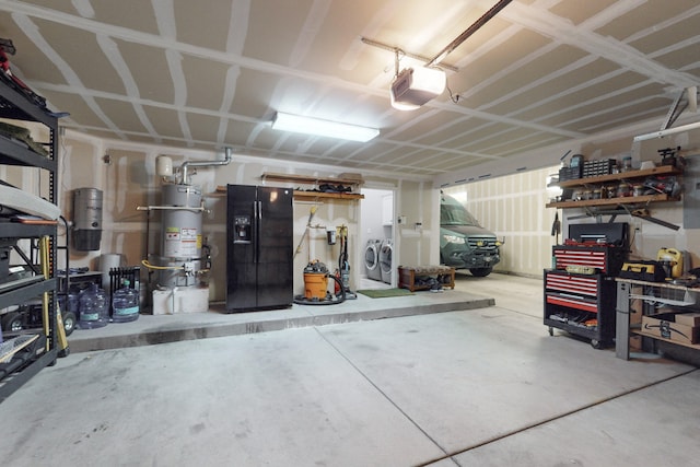 garage featuring black fridge, a garage door opener, separate washer and dryer, and gas water heater