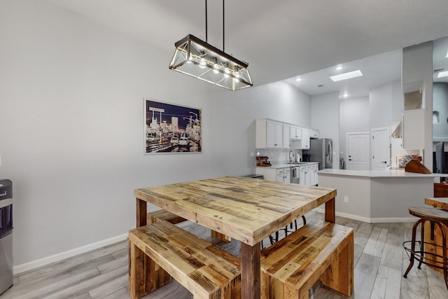 dining area featuring light hardwood / wood-style floors and a high ceiling