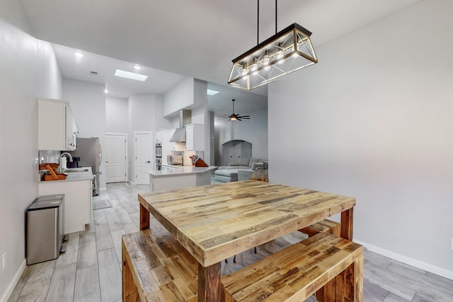 dining space featuring ceiling fan, sink, and light wood-type flooring