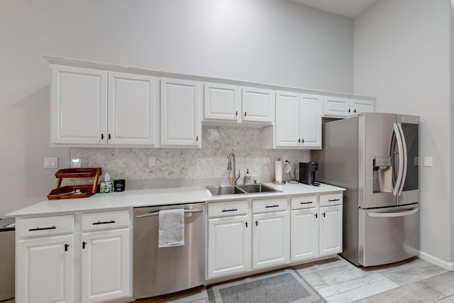 kitchen featuring stainless steel appliances, white cabinetry, sink, and decorative backsplash