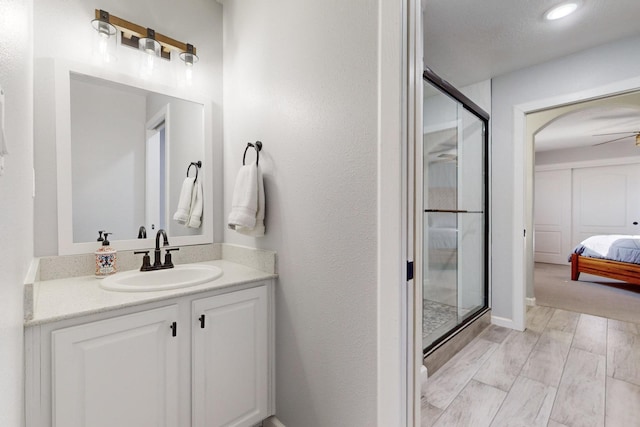 bathroom with vanity, an enclosed shower, and hardwood / wood-style floors