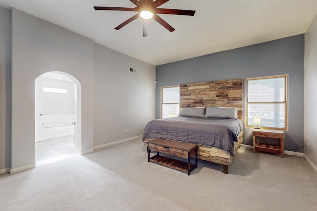 carpeted bedroom featuring ceiling fan and ensuite bath