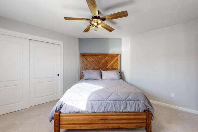 carpeted bedroom featuring ceiling fan and a closet