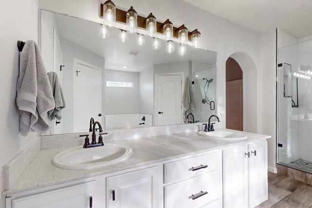 bathroom with vanity, hardwood / wood-style floors, and a shower with shower door