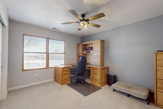 office featuring ceiling fan, light colored carpet, and a textured ceiling