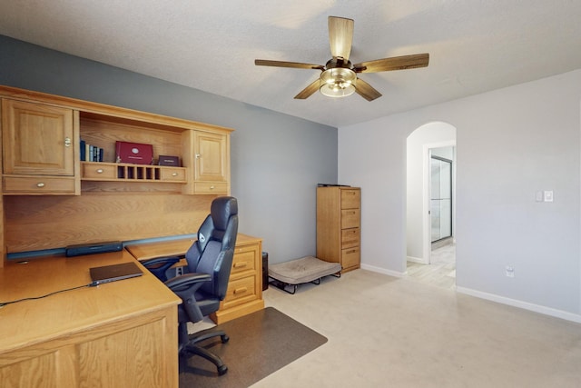 carpeted home office featuring ceiling fan