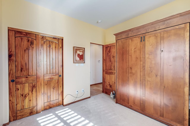 bedroom featuring light carpet and a closet