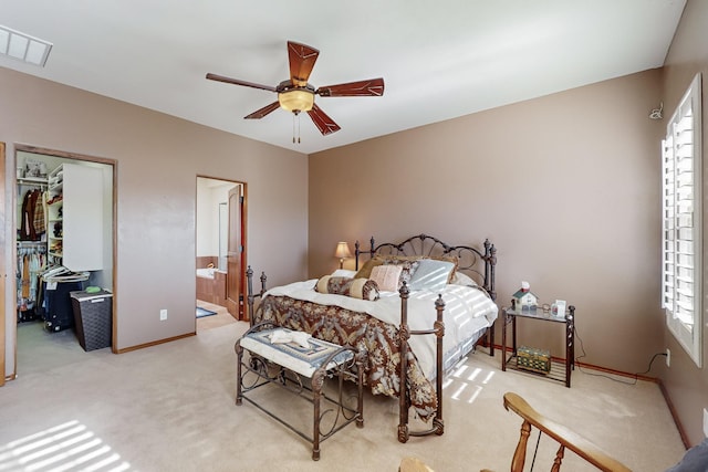 bedroom featuring ensuite bath, light colored carpet, and ceiling fan