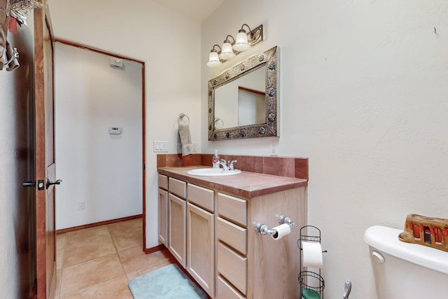 bathroom with vanity, tile patterned flooring, and toilet