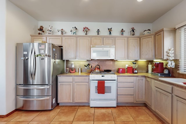 kitchen featuring white appliances, light tile patterned floors, and light brown cabinets