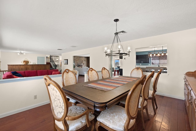 dining area featuring dark hardwood / wood-style floors, a chandelier, and a textured ceiling