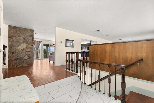 stairway featuring a fireplace and a textured ceiling